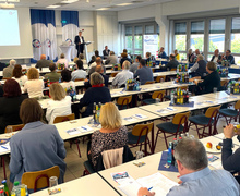Überblick über den gesamten Veranstaltungsraum mit Präsentationsfläche und Publikum.