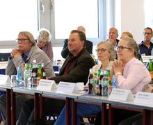 Teilnehmende sitzen an Tischen