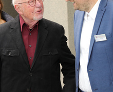 Zwei Männer im Gespräch, einer trägt ein Namensschild.