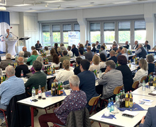 Überblick über den gesamten Veranstaltungsraum mit Präsentationsfläche und Publikum.