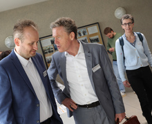 Zwei Männer stehen nebeneinander und unterhalten sich.